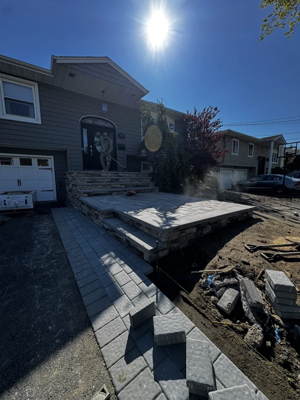 New front stoop with stone veneer, paver steps and matching paver walkway on a Levittown NY split-level home